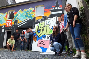 Dr. Detmar Freyhoff (Schwerter Zahnärzte) vollendet selbst gekonnt das Graffiti der Projektgruppe „VSI sagte danke“ zu den Zahnärzten vor dem Streetlife. Links daneben: Peter Frenz (VSI-Projektkoordinator) und Frau A. Fitzner sowie (rechts stehend) Margarete Brand (VSI-Vorstand). 